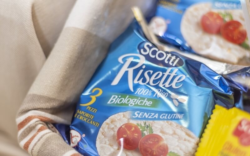 Close-up of Scotti Risette package with cherry tomatoes and herbs, highlighting gluten-free and organic features.