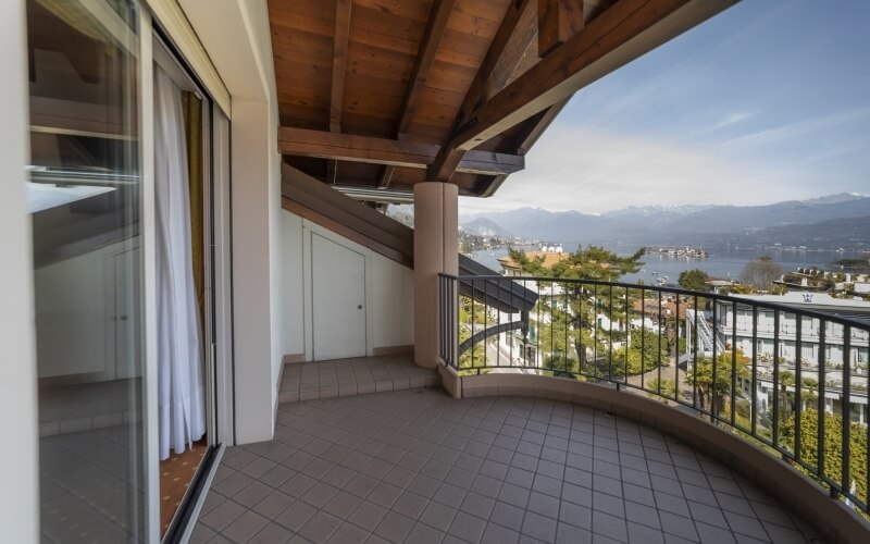 Serene balcony with a curved design, featuring a wooden ceiling, stunning landscape views, and elegant indoor elements.