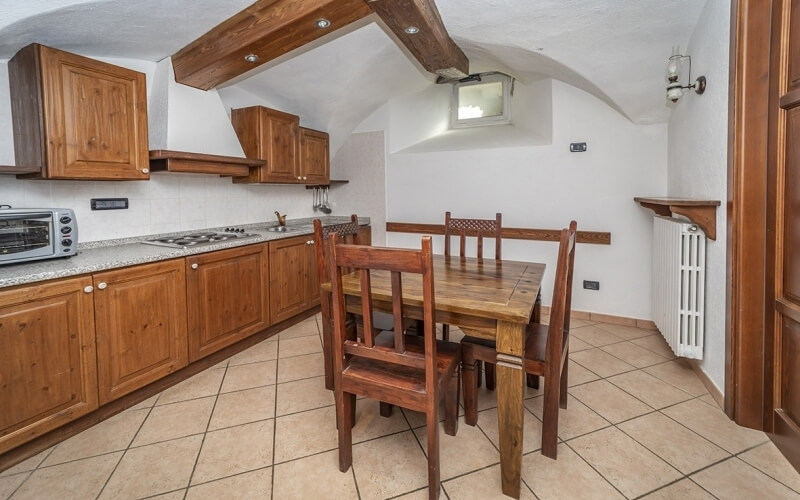 Cozy kitchen and dining area featuring a wooden table, four chairs, cabinets, and natural light from a window.