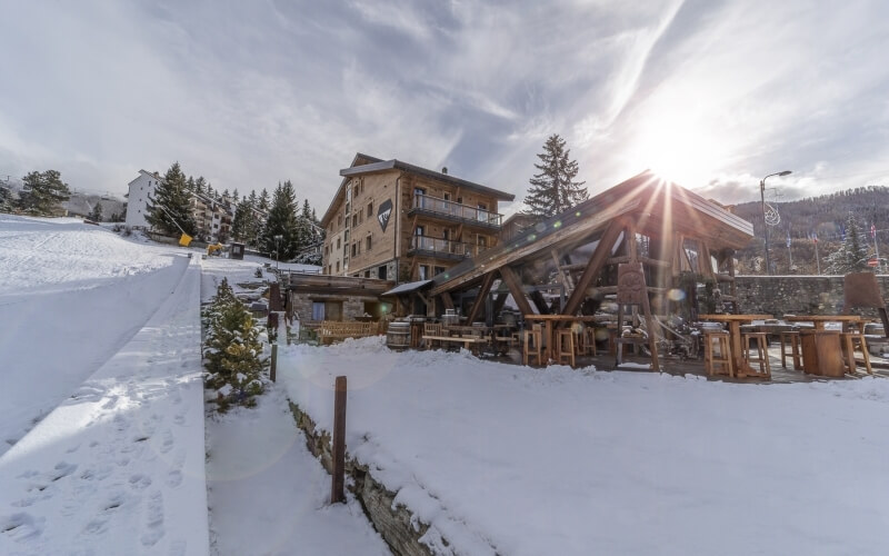Edificio in legno con balconi, area esterna e neve.