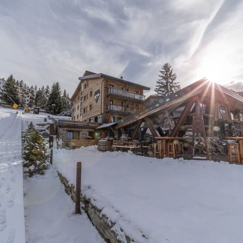 Edificio a più piani in un ambiente innevato con alberi.