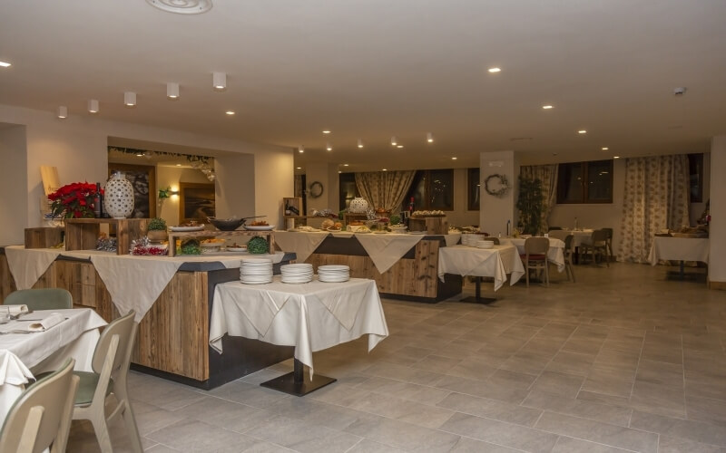 A well-lit room with white walls, tables set for a buffet, and decorative shelves, creating an inviting atmosphere.