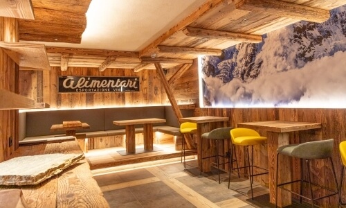 Rustic restaurant interior with wooden decor, mountain backdrop, warm light, and a weathered charm inviting cozy dining.