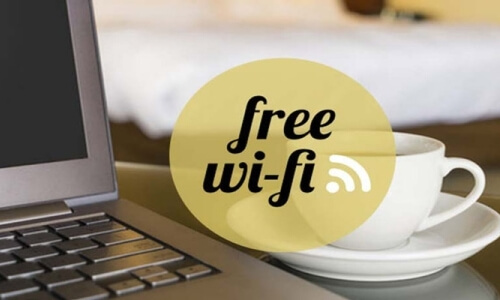 Laptop con schermo vuoto a sinistra, cerchio giallo con testo "free wi-fi" al centro, piatti bianchi a destra.