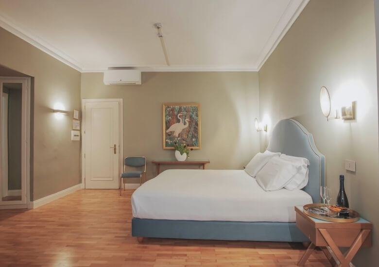 junior suite con letto e bottiglia sul comodino