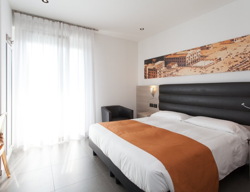 Modernes Schlafzimmer mit Doppelbett, sepia Stadtlandschaft, weißen Vorhängen und minimalistischer Einrichtung.
