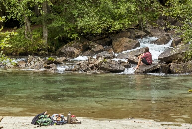 Sosta sulle rive del torrente durante un'escursione