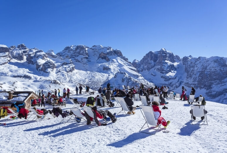 Sdraio al sole sulla neve davanti alle Dolomiti di Brenta