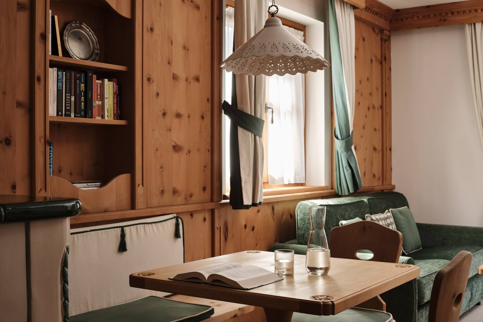Przytulny salon i jadalnia z drewnianymi meblami, zielonymi akcentami i białymi ścianami, tworzące ciepłą