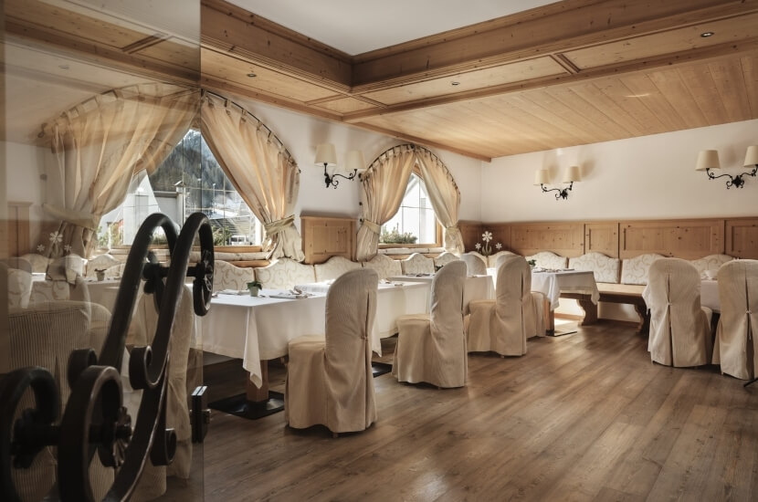 Ein einladendes Esszimmer mit warmen Farben, eleganten Möbeln, großen Fenstern und einem gemütlichen Ambiente.