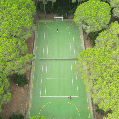 Vista aerea di un campo sportivo verde con rete e persone.