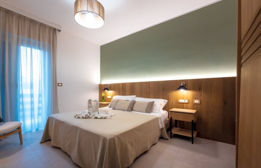 Camera d'hotel con letto grande, cuscini e decorazioni eleganti.