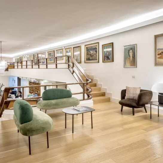 Interno multi-livello con scala, opere d'arte e mobili eleganti.