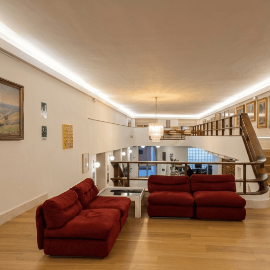 Red sofas with a coffee table in a two-level room.
