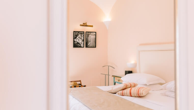 Cozy hotel room with a bed, luggage rack, and decorative accents.