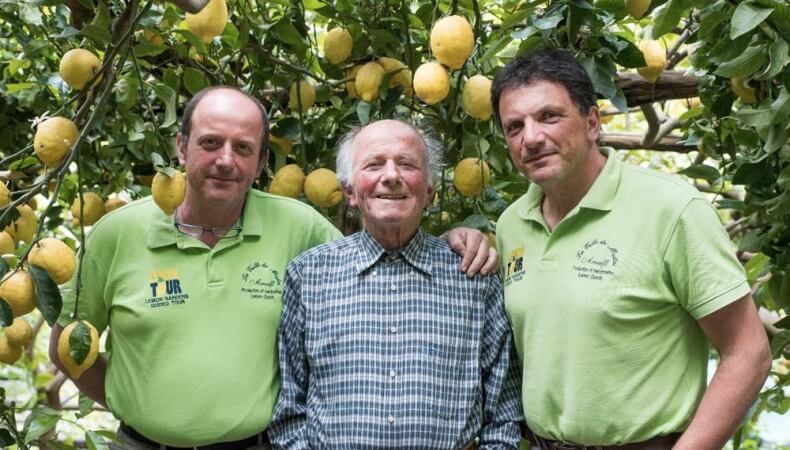 People posing for group photo with lemon plant