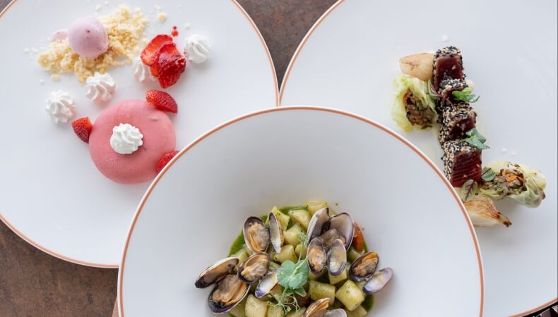 Tre piatti bianchi con cibi: dessert, tonno e gnocchi.