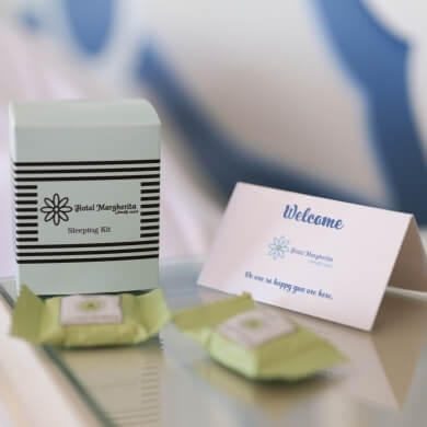 Kit da letto "Hotel Marghertia" con carta di benvenuto e articoli avvolti.