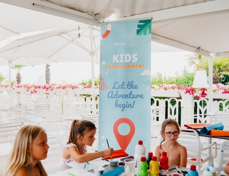 Tre ragazze a un tavolo per attività creative all'aperto.
