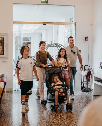Una famiglia cammina in un edificio con un passeggino.