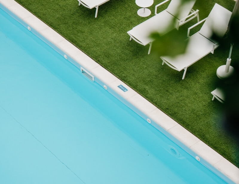 Swimming pool with lounge chairs and a 1.5m depth marker.