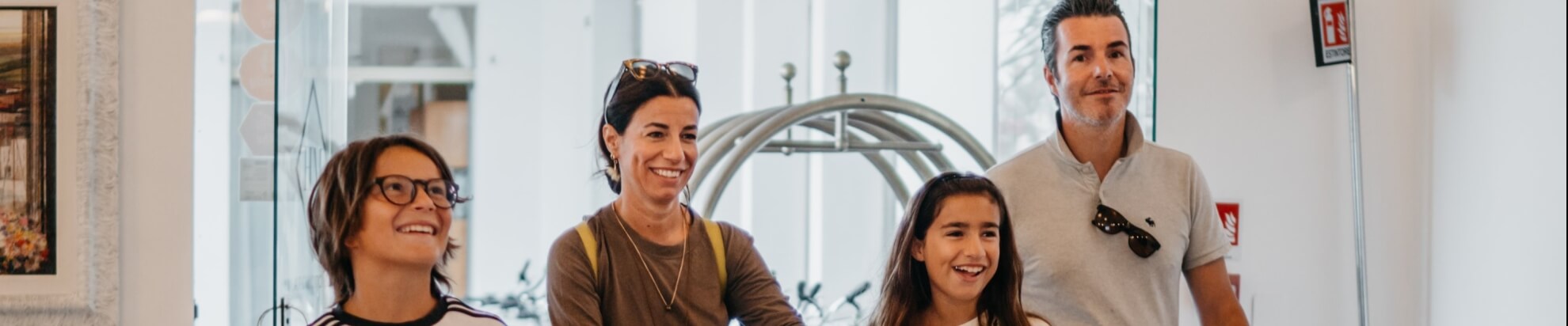 Quattro persone con bagagli, in un ambiente interno.