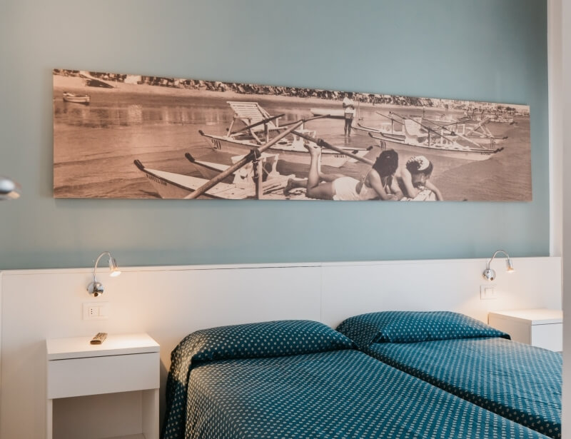 Camera d'hotel con due letti singoli e fotografia panoramica.