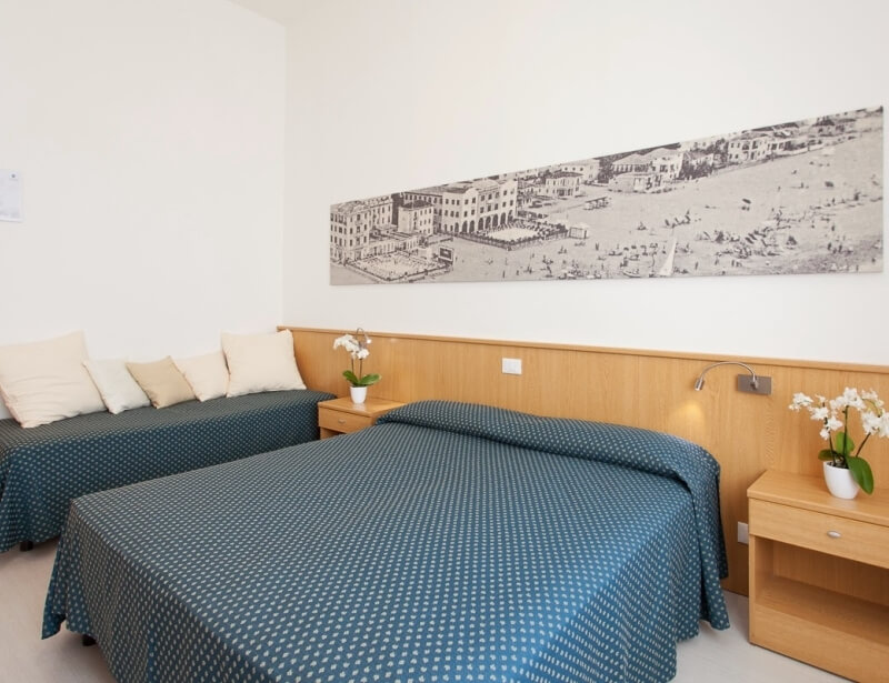 Camera d'hotel con due letti e arte marina sopra.