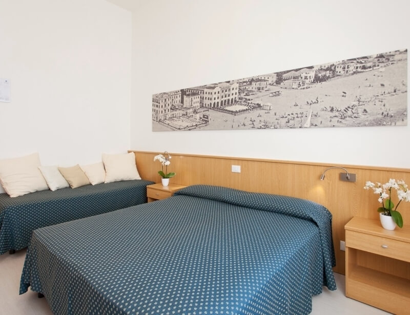 Hotelzimmer mit zwei Betten, Stadtbild über den Betten, Orchideen.