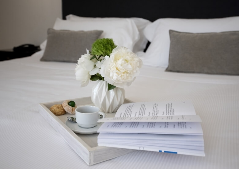 tray with two pastries and a cup in bed