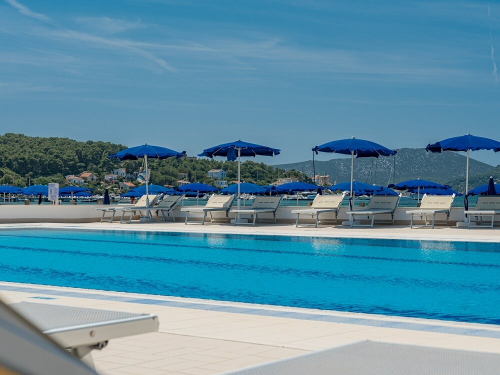 swimming pool with sun loungers and parasols
