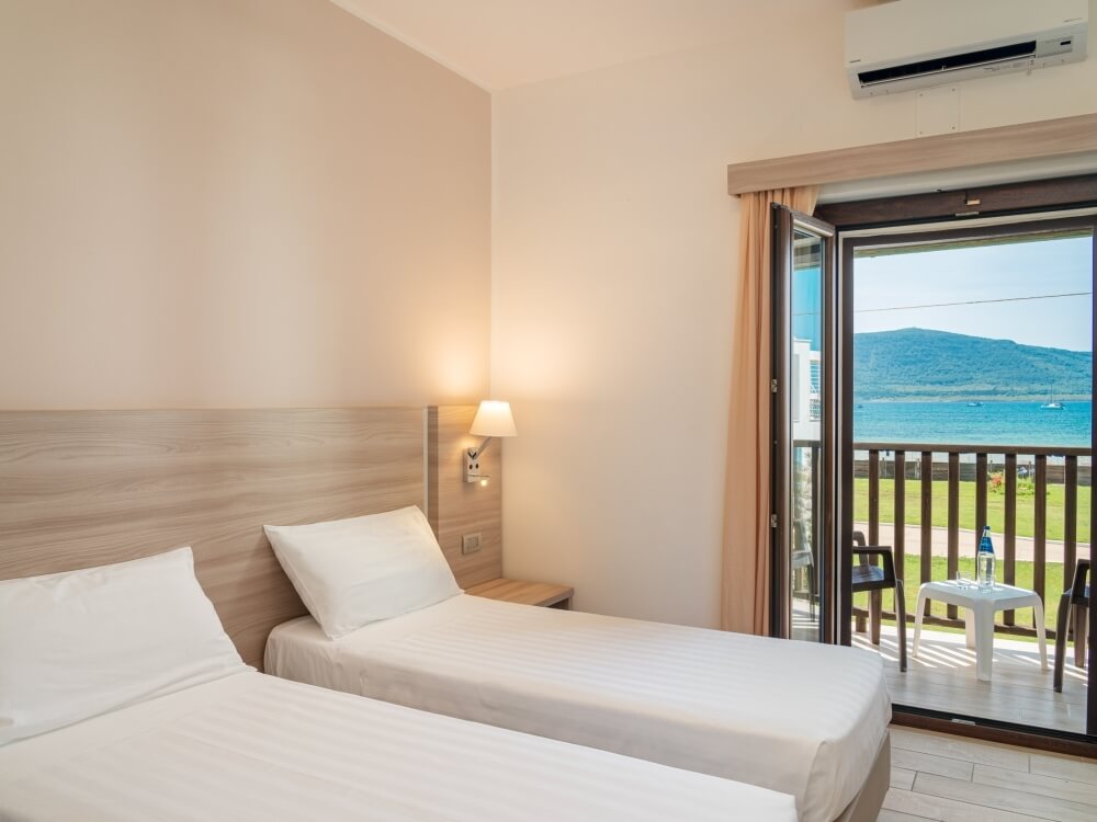 room with two double beds and sea view terrace
