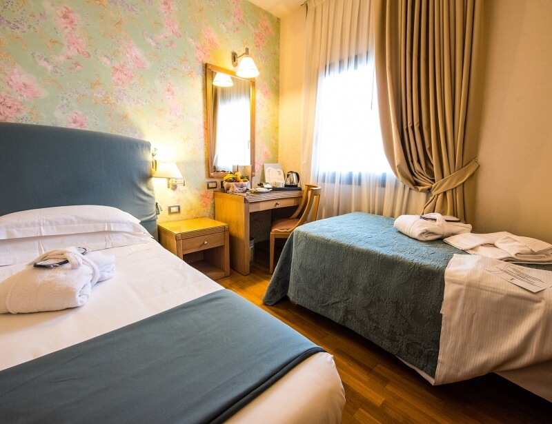Room with double bed and single bed in hotel in Carpi
