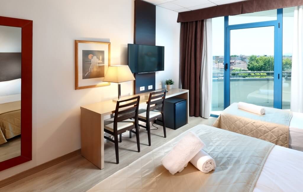 room with double and single bed with balcony