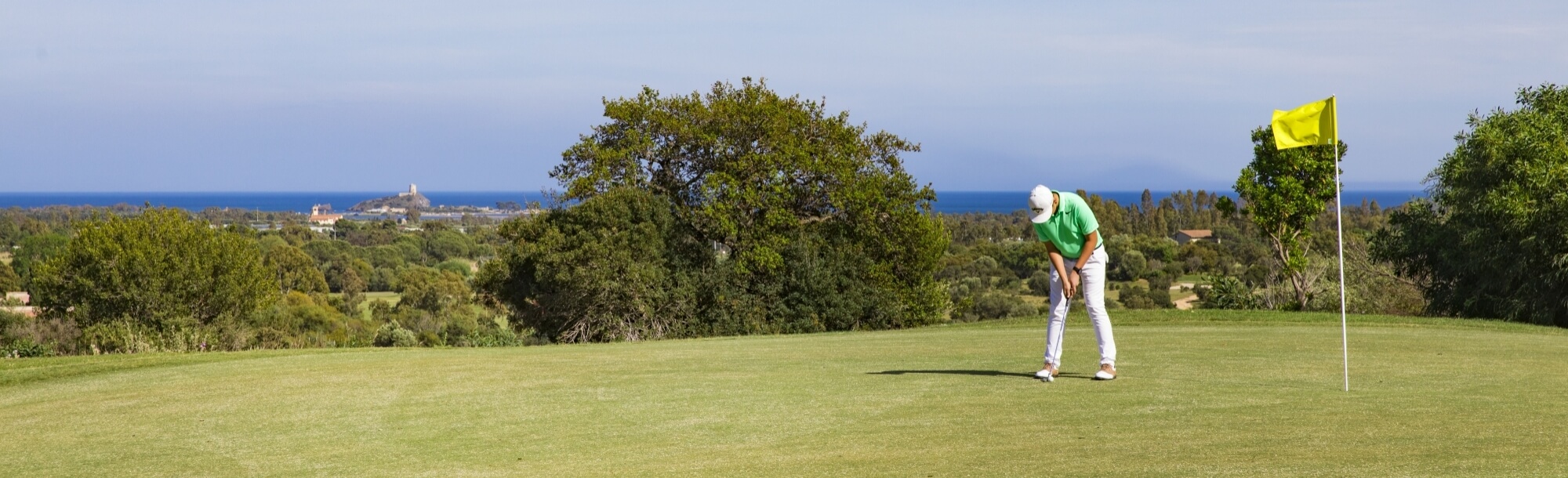 Uomo su campo da golf vista mare