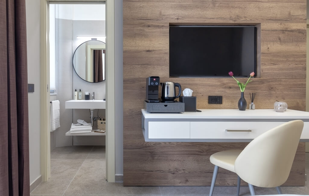 Camera d'hotel moderna con scrivania, TV, bagno e decorazioni eleganti. Atmosfera pulita e lussuosa.