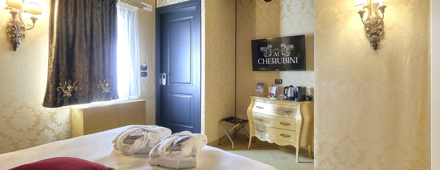 Camera d'hotel con letto, TV, e comodità per il caffè.