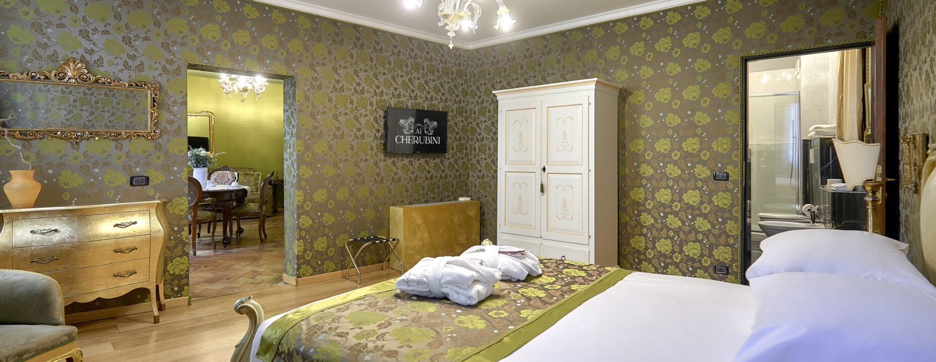 Camera d'hotel con letto grande, armadio bianco e area pranzo.