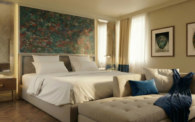 Camera d'hotel con letto king, divano e opere d'arte.