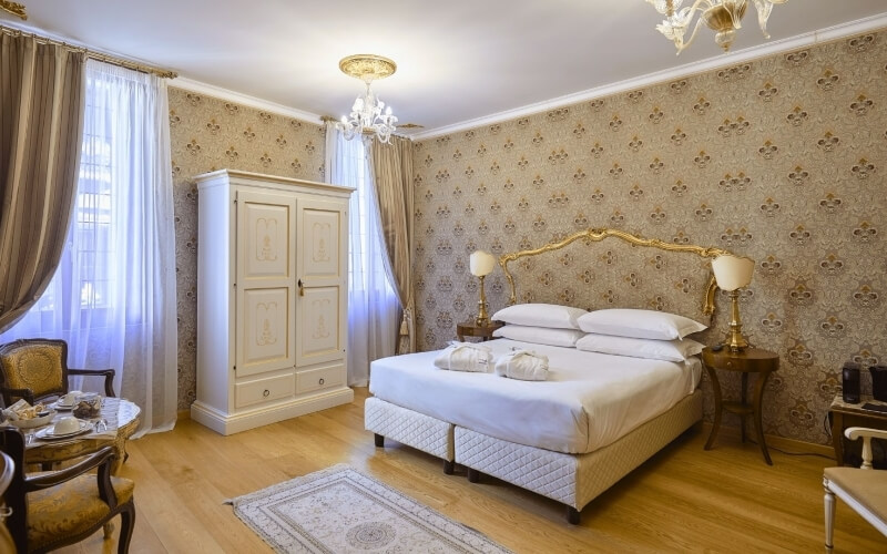 Camera d'hotel con letto grande, armadio bianco e servizio da tè.