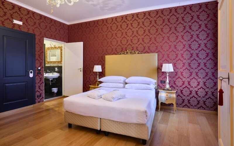 Camera d'hotel con letto, armadi, lampade e bagno.