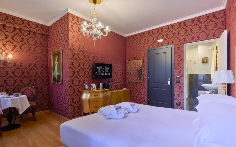 Camera d'hotel con letto king-size, decorazioni eleganti e area tè.