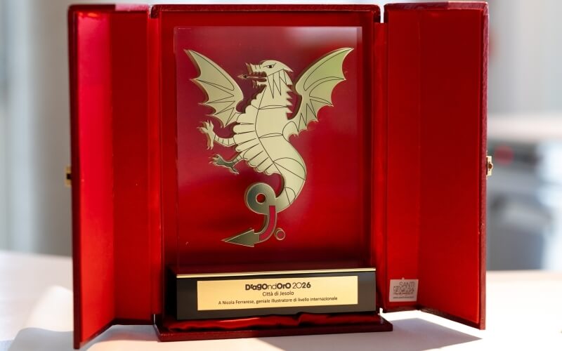 Cassa rossa con un premio dorato e testo commemorativo per Nicola Ferrarese.