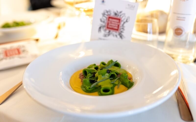 Pasta verde su salsa gialla, guarnita con caviale e erbe.
