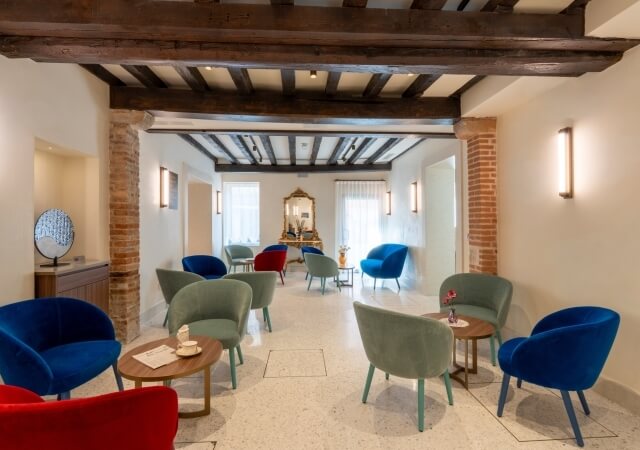 Colorful upholstered chairs and wooden tables in a cozy seating area.