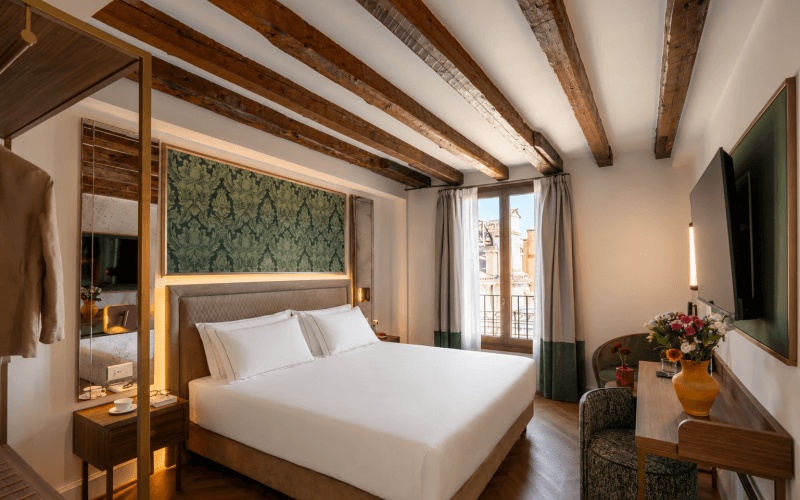 Camera d'hotel con letto king-size, scrivania e vista sulla città.