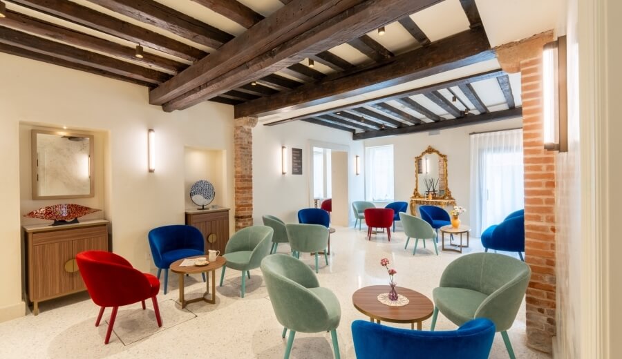 Area lounge con poltrone colorate e decorazioni eleganti.