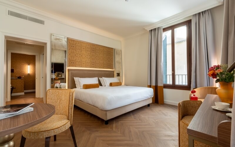 Hotelzimmer mit Kingsize-Bett, Fenster und gemütlicher Einrichtung.