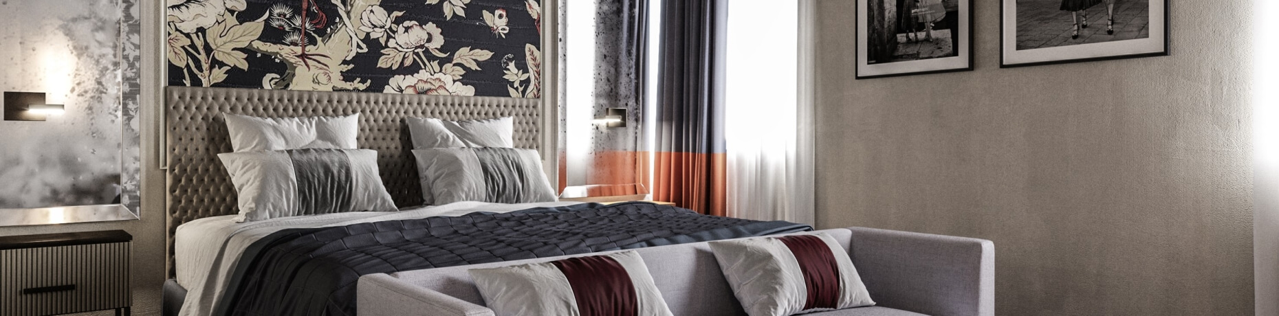 Camera elegante con letto grigio, biancheria bianca, murale floreale e angolo lettura accogliente.