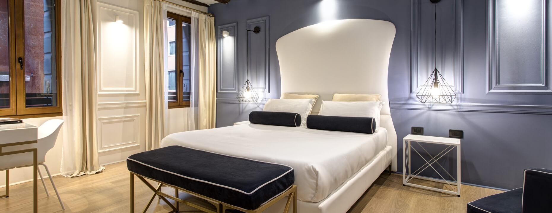 Camera d'hotel elegante con letto bianco e decorazioni moderne.